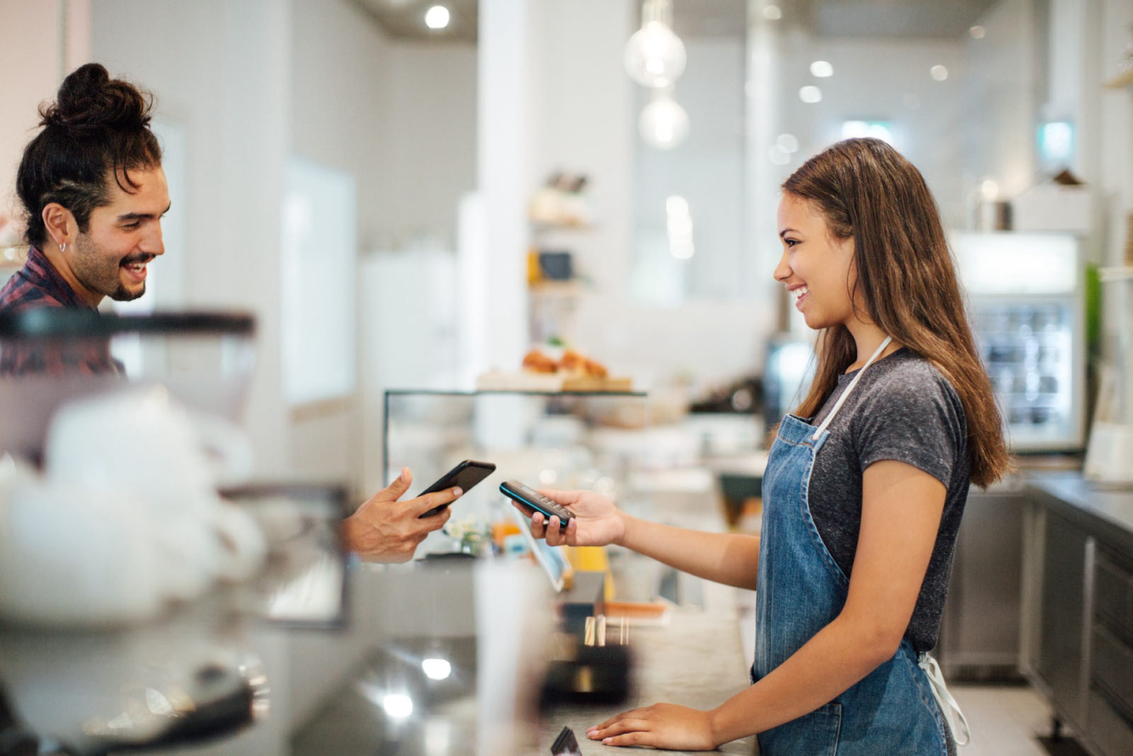 a barista smiling while assisting a customer
