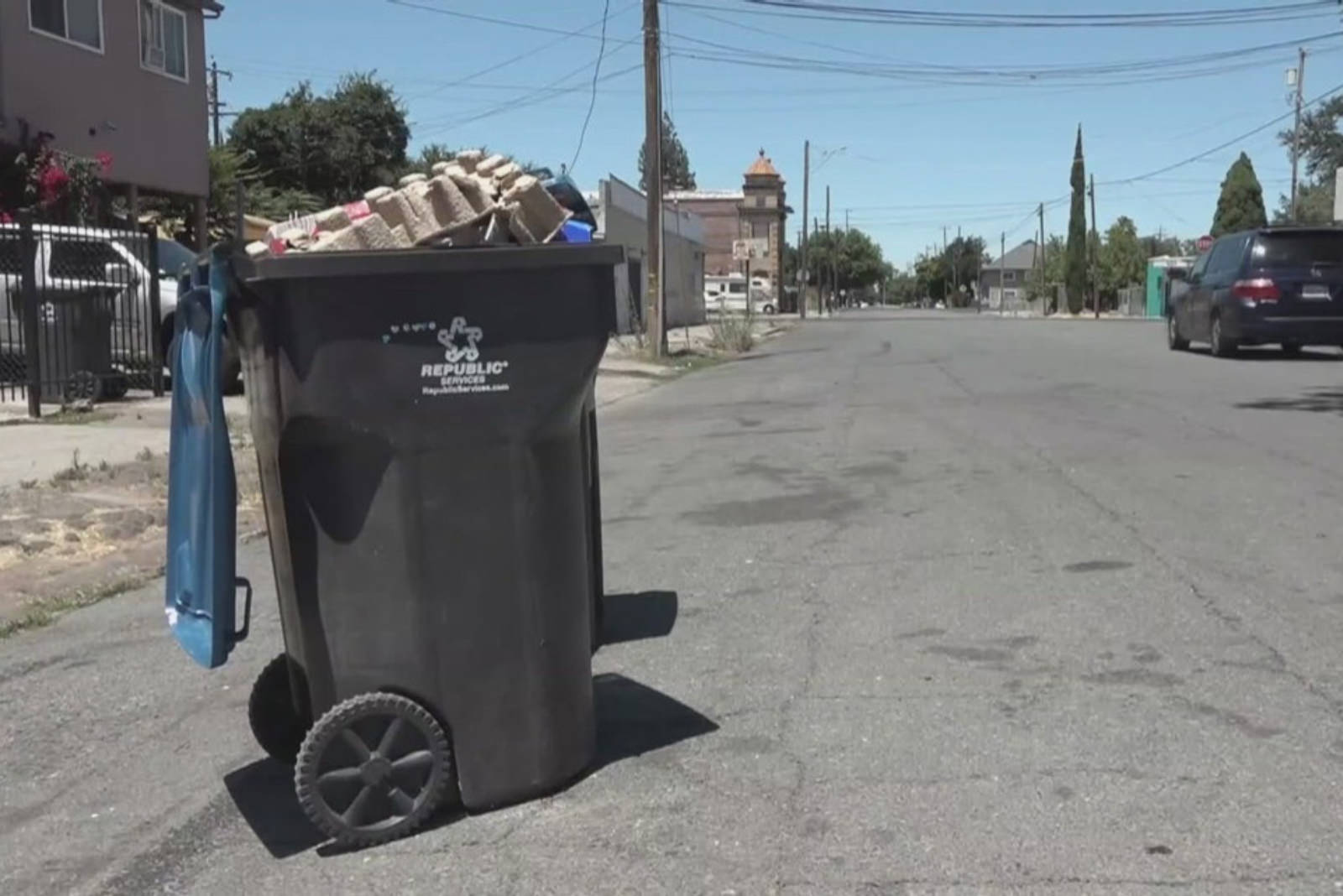 a full trash can sitting in the street