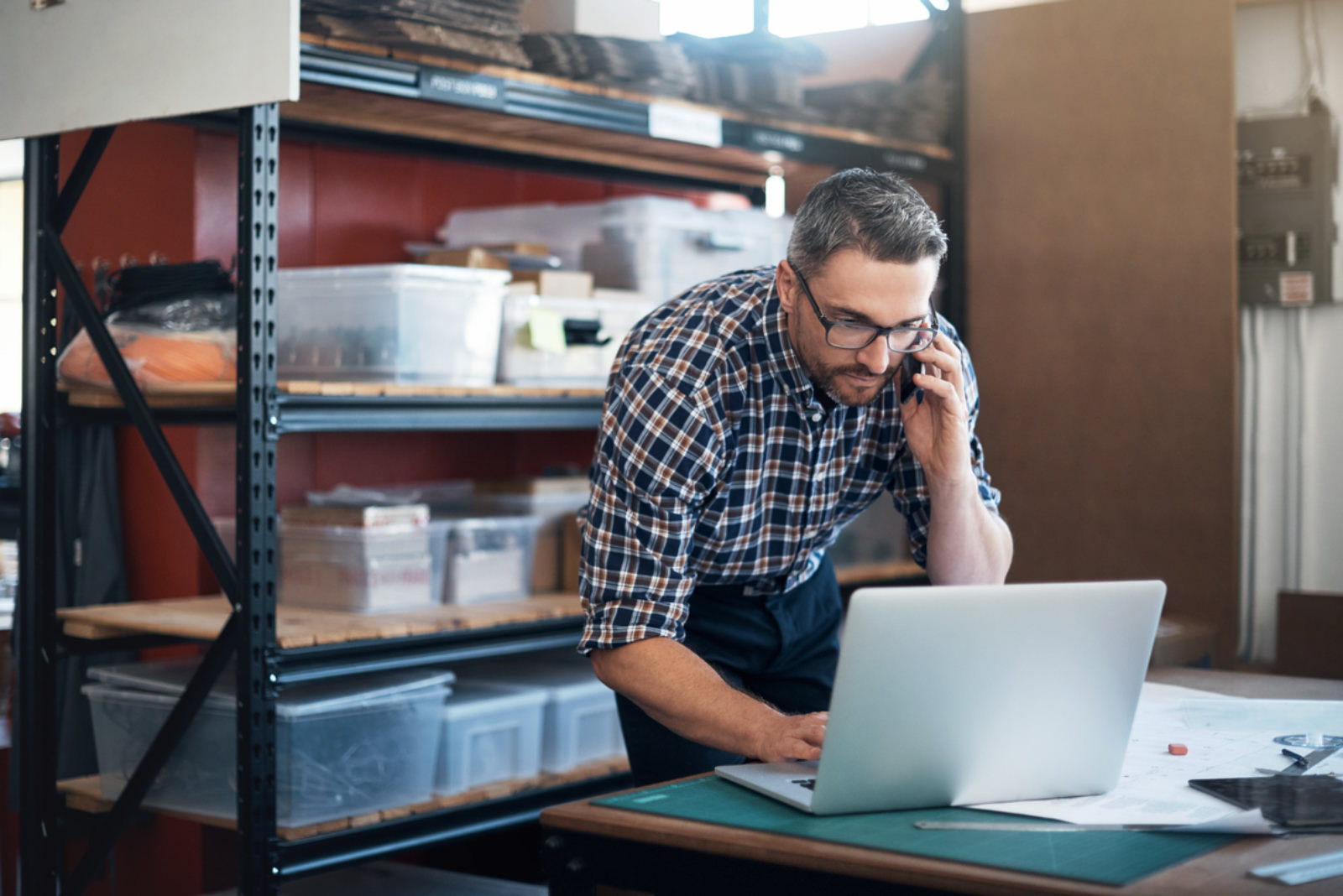 a business owner talking on the phone while look at his laptop