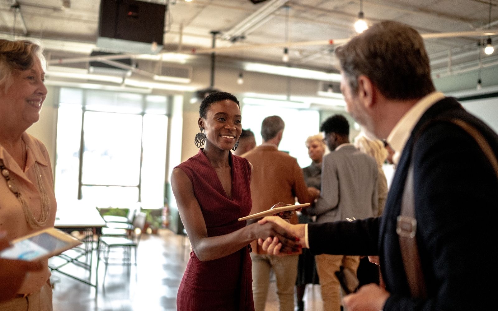 Business professionals shaking hands during a networking event in a modern workspace